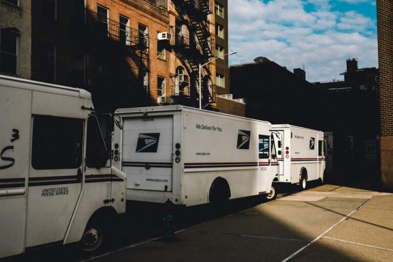 Row of commercial delivery vans and lorries parked in a fleet yard, representing the choice between leasing and buying a commercial vehicle in Singapore