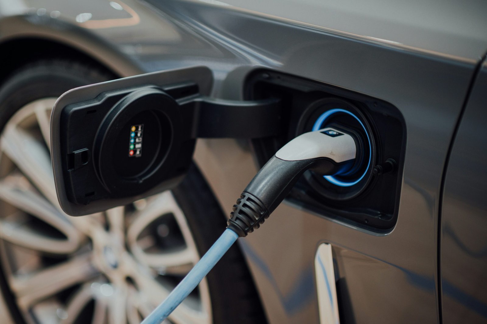 Electric vehicle charging cable plugged into a car, illustrating the electric side of a diesel versus electric fuel cost comparison