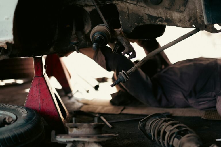 Mechanics at work in a busy automobile repair garage, illustrating common commercial vehicle repairs and their costs in Singapore