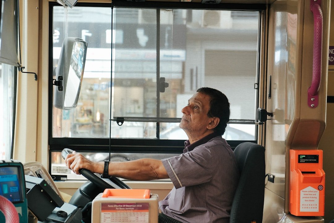 A bus driver at the wheel in Geylang, Singapore, illustrating driving licence class requirements for commercial vehicle drivers