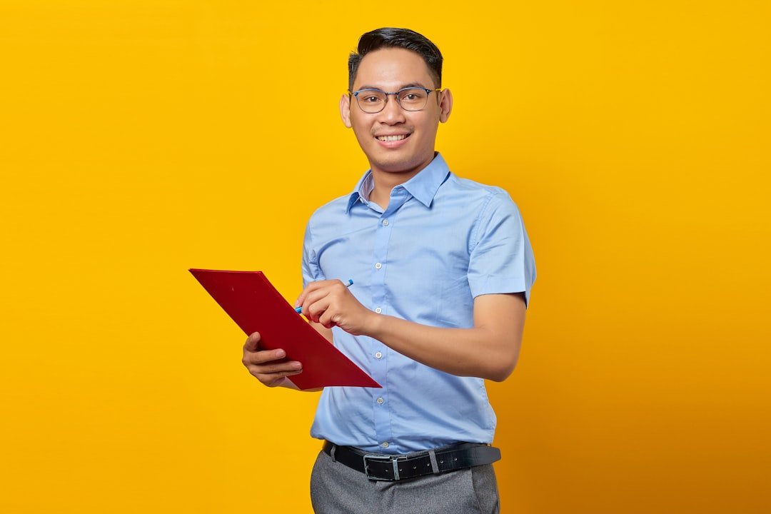 Asian businessman holding a document folder, representing a Singapore fleet manager weighing whether to lease or buy a commercial vehicle