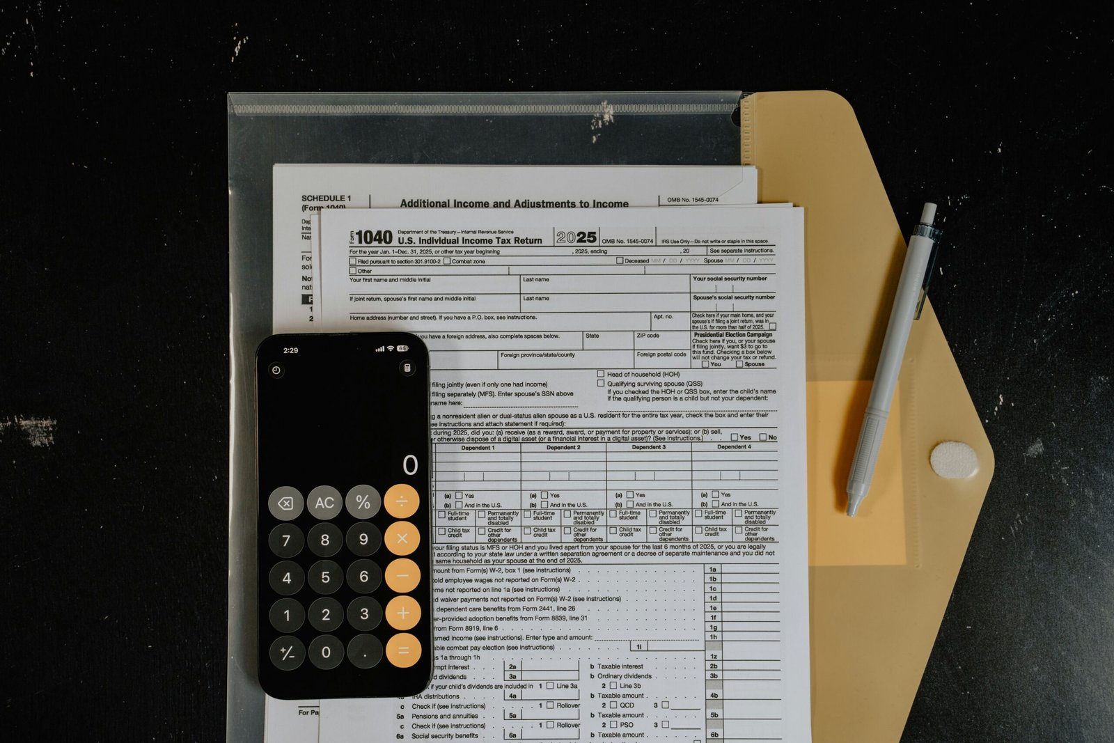 Calculator and pen resting on insurance claim paperwork, used when working out the cost impact of an at-fault accident claim