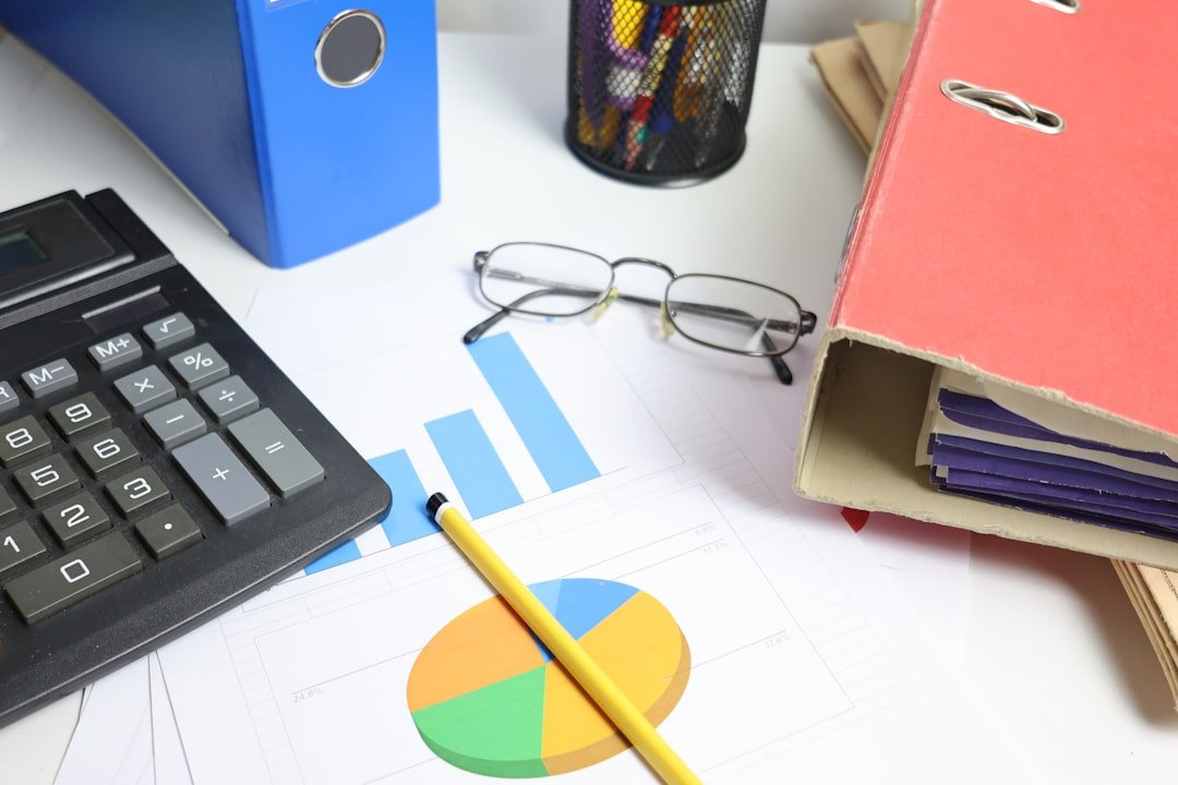 Desk with calculator and financial charts used to work out interest rates and tax treatment on a commercial vehicle financing loan in Singapore