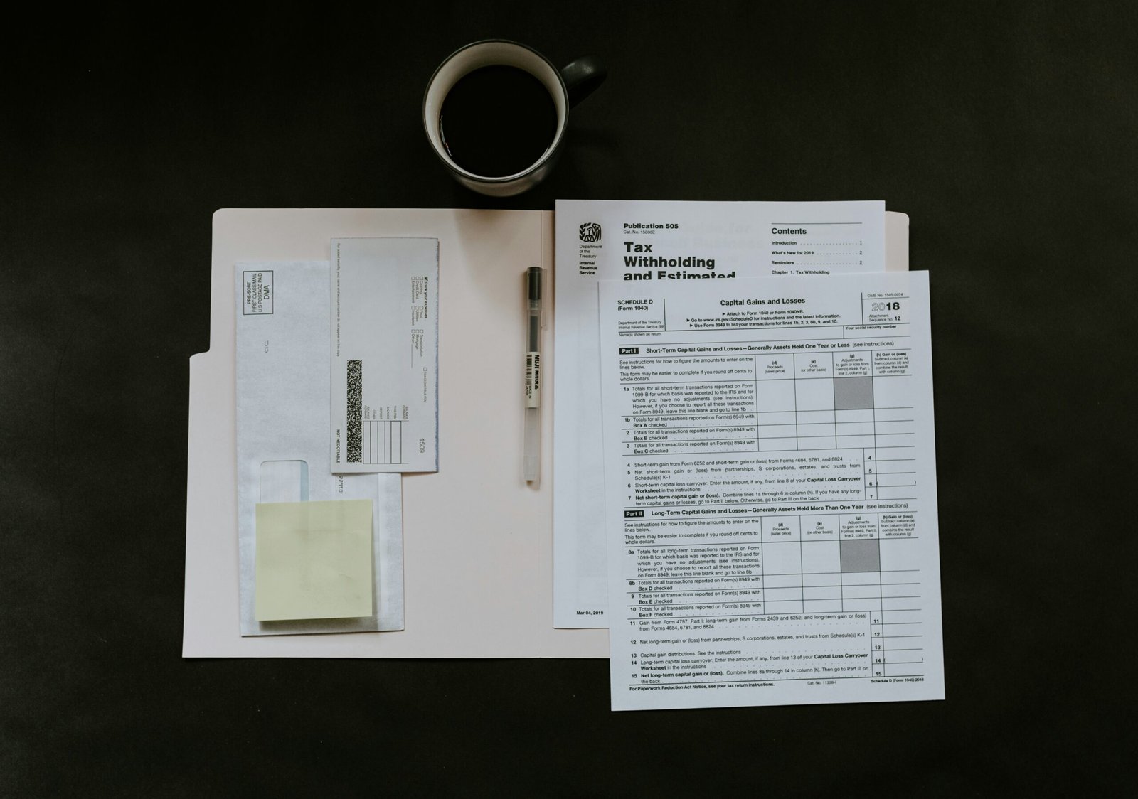 Insurance paperwork, pen and coffee mug on a desk, representing the claim forms involved in a commercial motor insurance claim