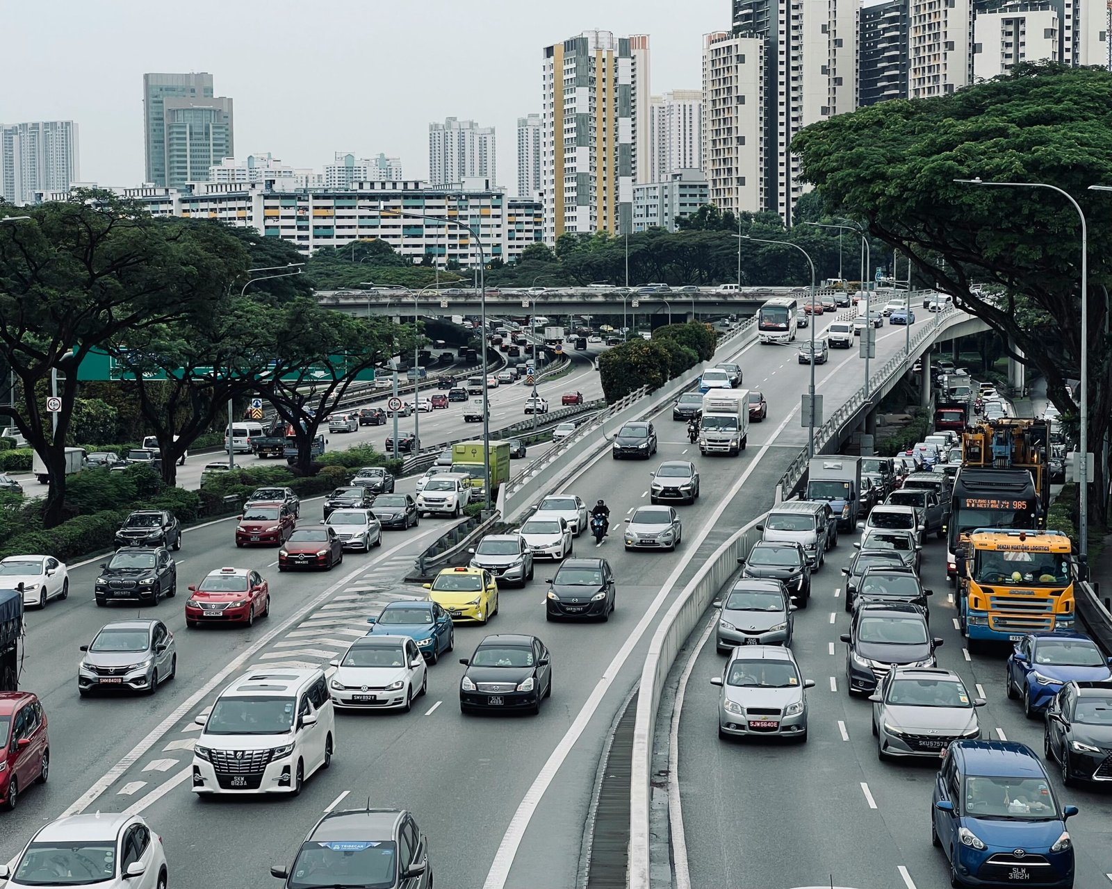 Diesel commercial vehicles and buses on a busy Singapore expressway, representing the diesel fleet side of the EV vs diesel TCO comparison