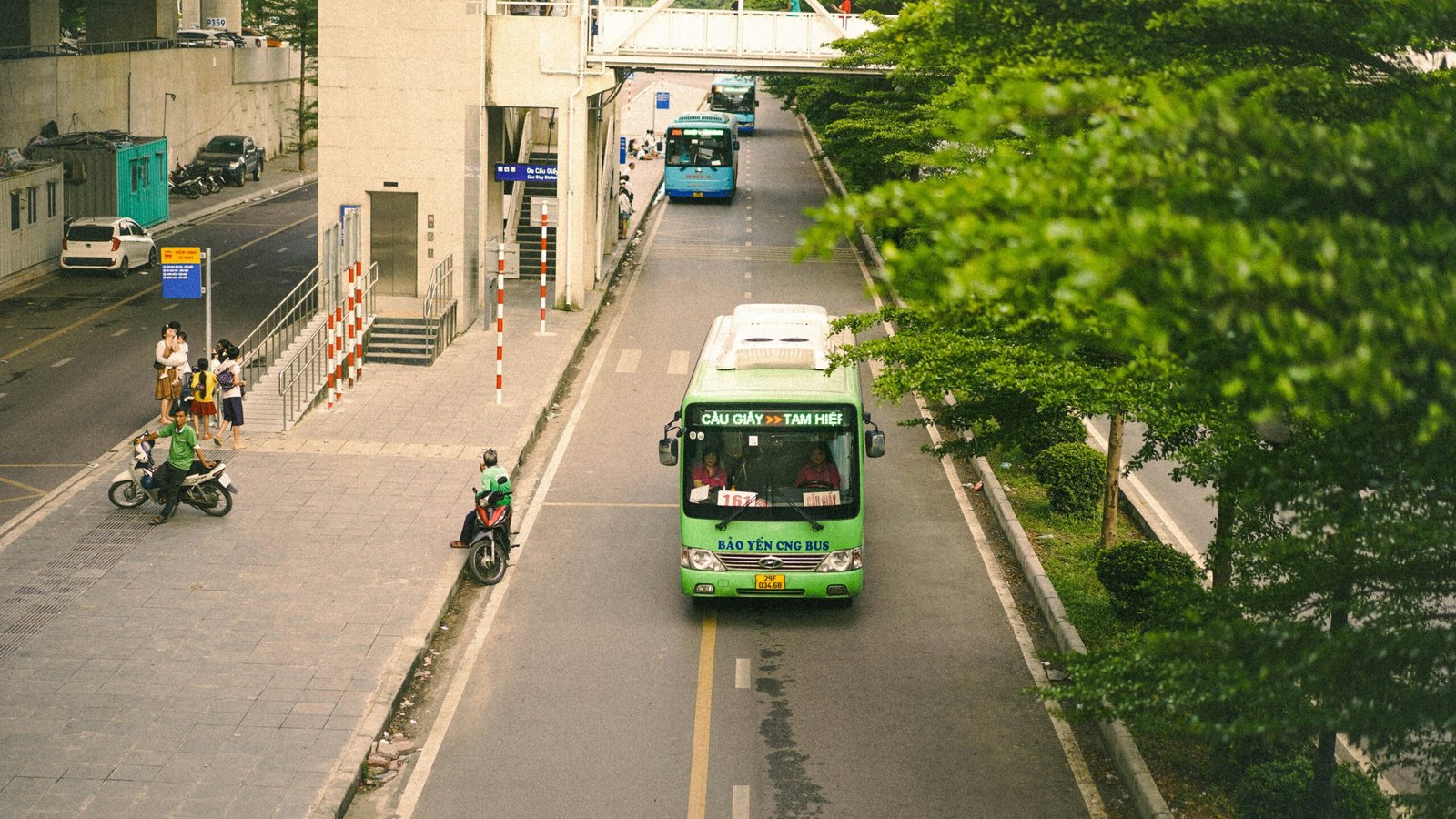 An electric bus travelling through a Southeast Asian city street, illustrating electric commercial vehicles on public roads