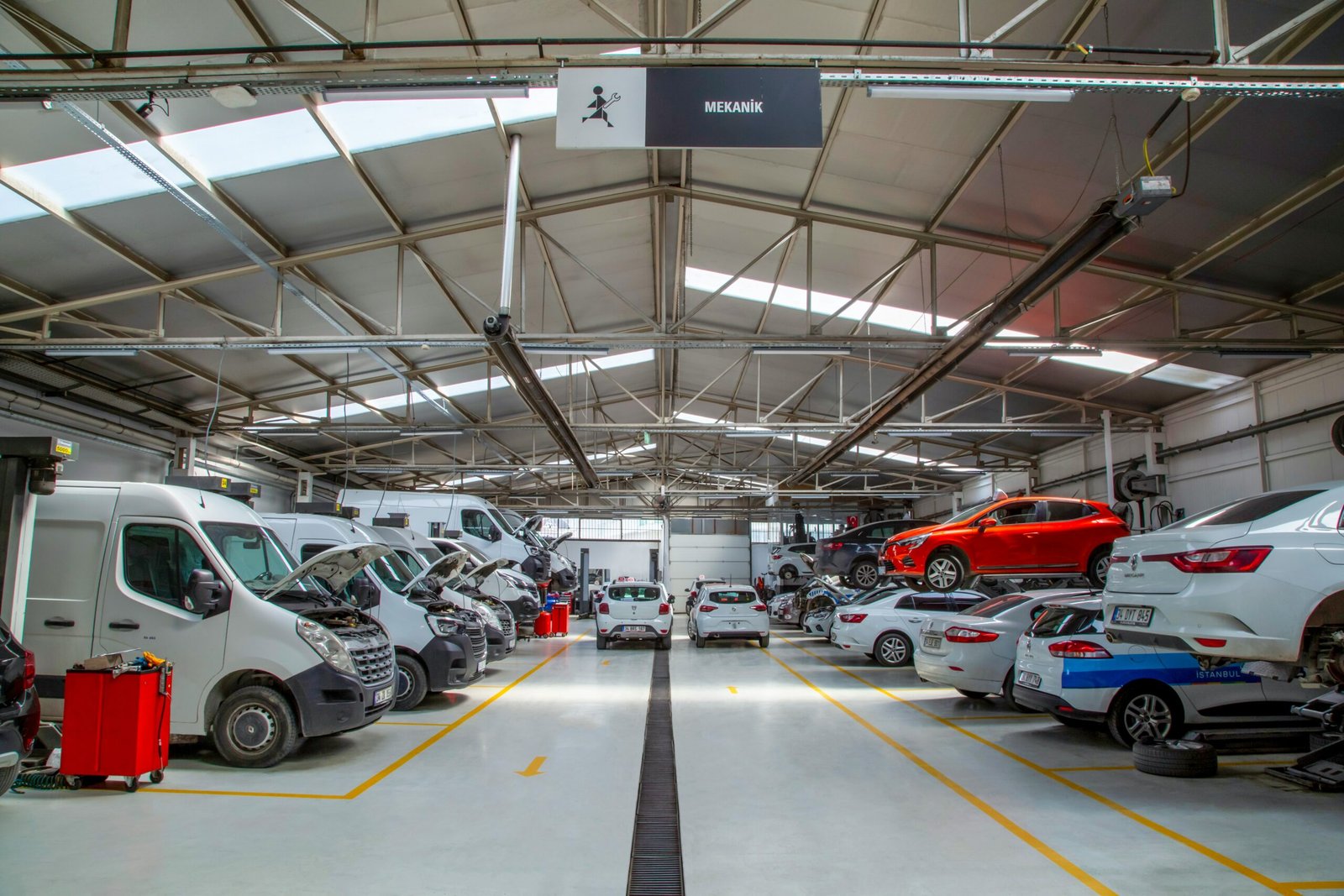 A fleet maintenance warehouse with multiple commercial vehicles, representing an in-house workshop setup for Singapore fleet operators