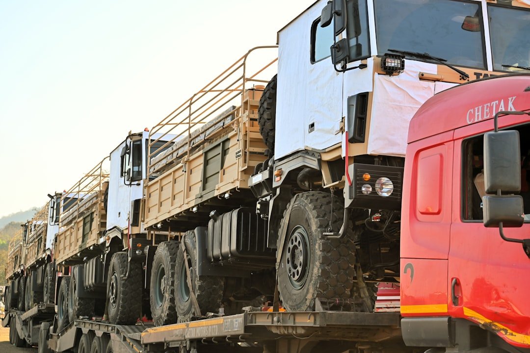 Row of parked commercial trucks representing a Singapore fleet weighing COE renewal financing against scrapping and replacing older vehicles