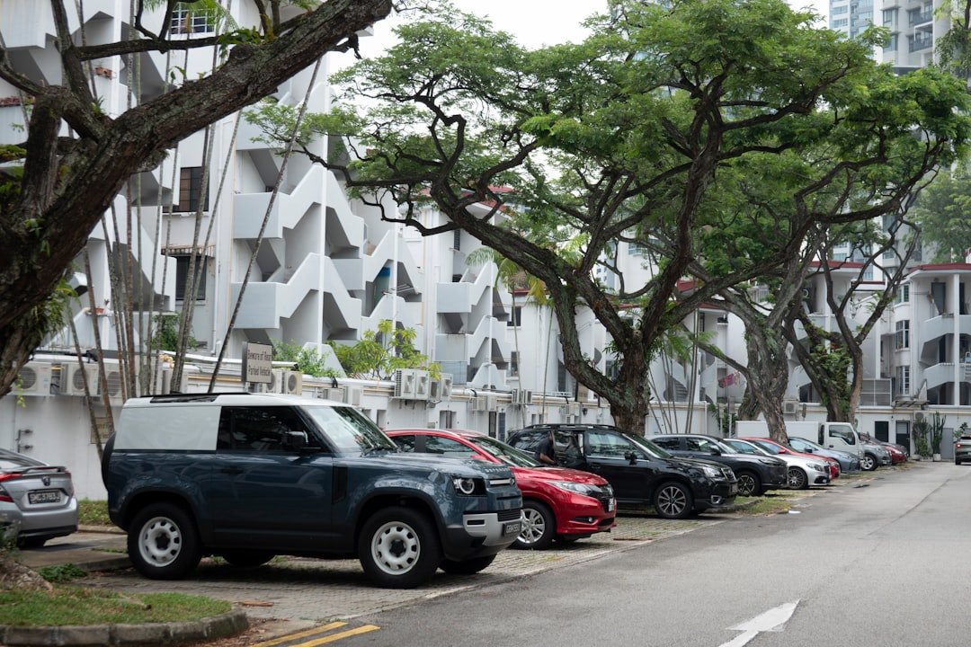 Row of parked commercial vehicles on a Singapore street, illustrating the fleet vehicles a leasing company insures throughout the contract term