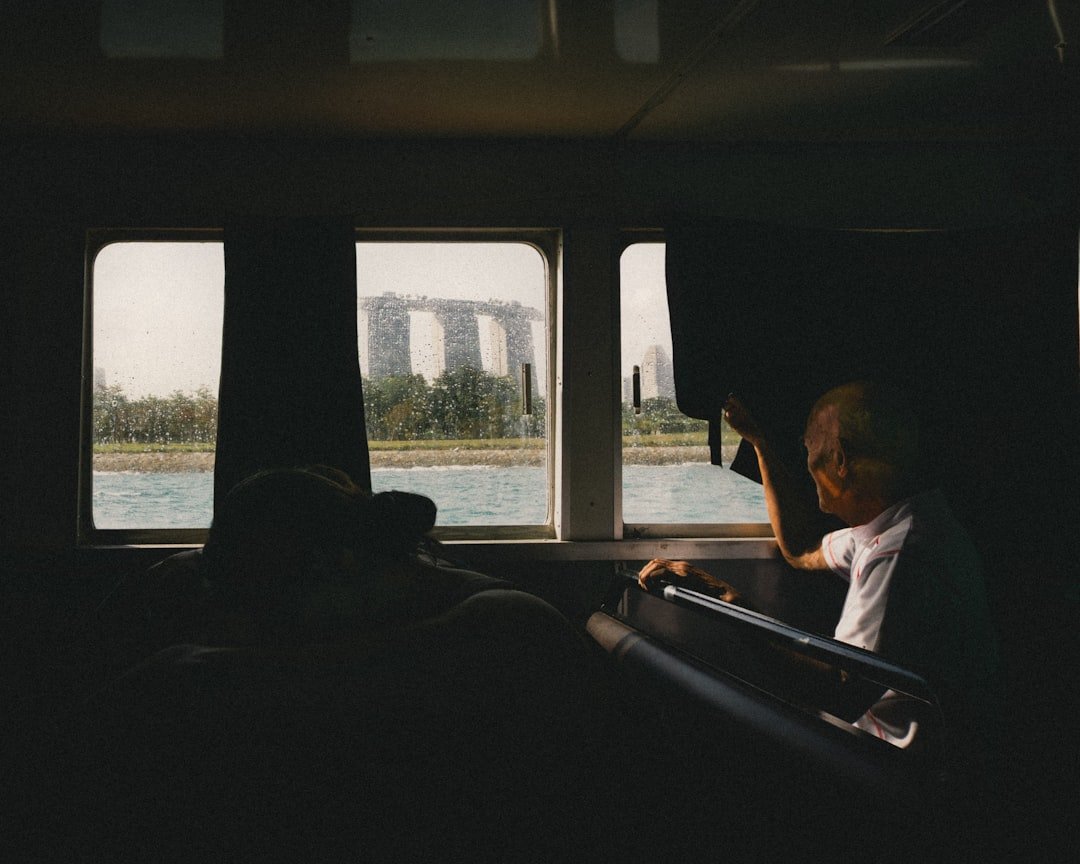 Passenger sitting on a bus looking out the window, illustrating worker transport for Singapore commercial fleets