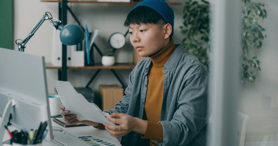 An office worker processing payroll and levy payment documents, relevant to how Singapore's foreign worker levy is computed and paid
