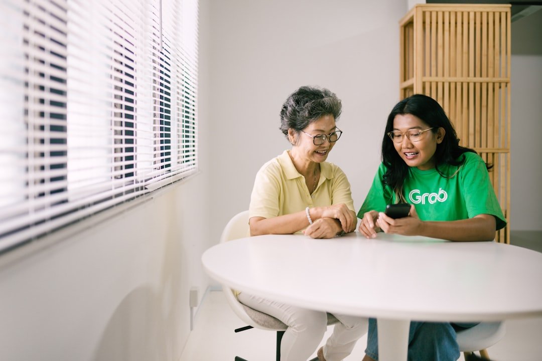 Two people reviewing vehicle sale documents at a table, illustrating the paperwork checks buyers should complete before purchase