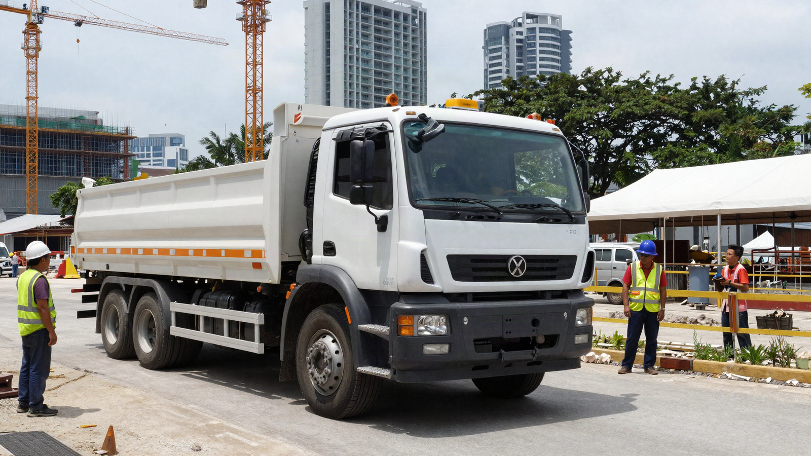 3-axle tipper truck with an X-plate at a Singapore construction site, with Asian construction workers and cranes in the background