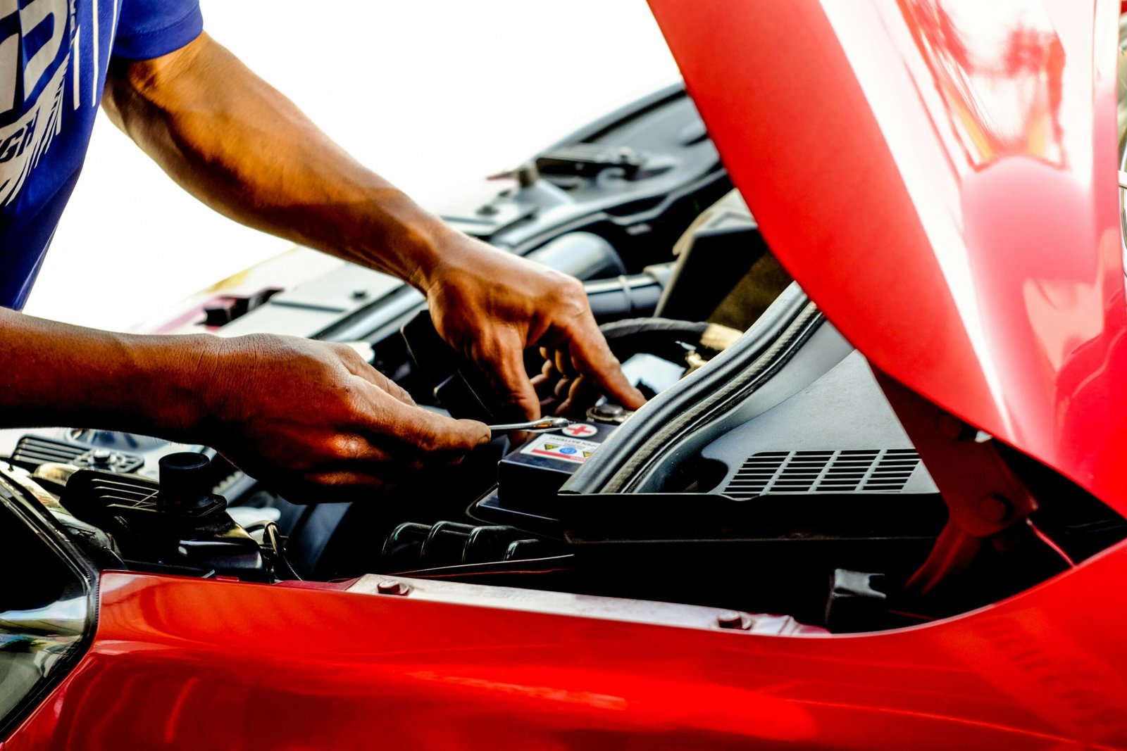 A technician performing scheduled maintenance checks on a vehicle, part of a commercial fleet maintenance routine in Singapore